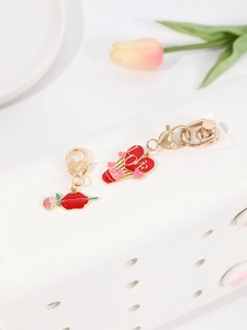 Detail of lobster clasp heart and red lip enamel charms on a white storage rack
