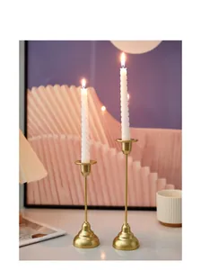Detail view of gold iron candle holder set with elegant spiral white candles