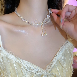 Detail shot of crystal beaded bow necklace on neck with delicate teardrop pendants