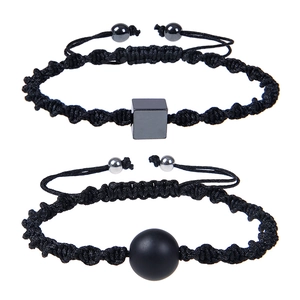 Detail view of handmade braided bracelets with black square and spherical magnetic charms