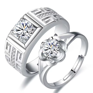 Close-up of silver couples rings with geometric textures and round diamond settings