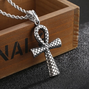 Gros plan du pendentif Ankh en argent vintage avec texture de peau de serpent sur bois
