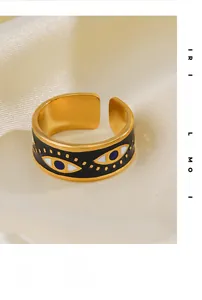 Détail d'une bague vintage œil protecteur en émail noir sur fond de tissu en soie