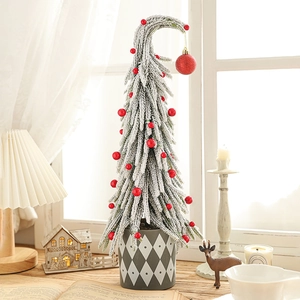 Miniature snow-flocked Christmas tree with red berries and a grey diamond-pattern pot
