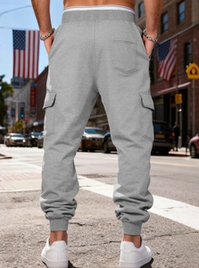 Detail view of grey cargo joggers with fleece lining, large flap pockets and ribbed cuffs
