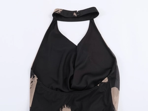 Detail showing halter neck design with dual button closure on black printed dress