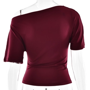 Vista posteriore dettagliata del top asimmetrico bordeaux in morbida maglia