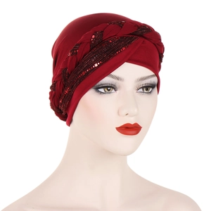 Detailed view of dark red turban hat with braided sequin design on mannequin