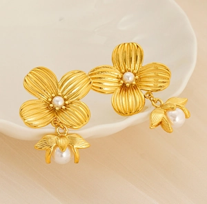 Macro detail of vintage gold flower pearl earrings with textured brushed petals
