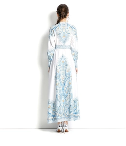Back view of a long floral paisley print dress with raglan sleeves and stand collar