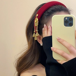 Ethnic velvet headband with red fabric, golden tassels and bells on a model