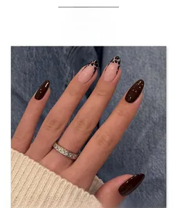 Close-up of almond leopard print press-on nails with blue denim and knit background