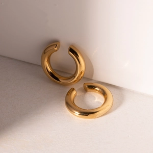 Minimalist chunky gold hoop earrings in high-polished stainless steel on white pedestal