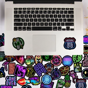 Neon graffiti waterproof stickers set displayed on a silver laptop and background