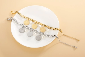 Détail de bracelets cœur dorés et argentés avec perles sur une assiette blanche