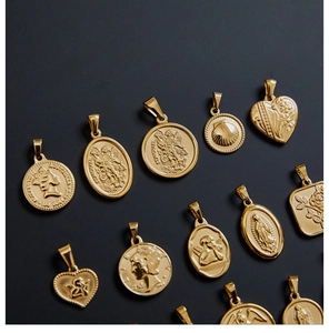 Macro detail of assorted vintage 18K gold plated titanium steel coin and religious pendants