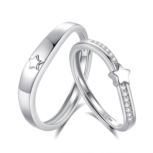 S925 sterling silver couple rings with star pattern and shimmering stones on white background