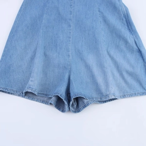 Combishort en jean bleu clair avec coutures détaillées et ourlet sur fond blanc propre