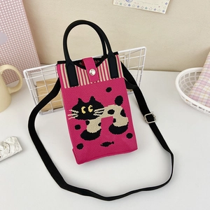 Detail of hot pink knitted phone bag featuring black cat pattern and adjustable strap