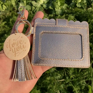 Detail view of pink gold card holder with tassel and engraved I love you wooden pendant