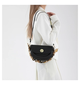 Model showing a black half-moon saddle bag with golden lock and leopard scarf chain