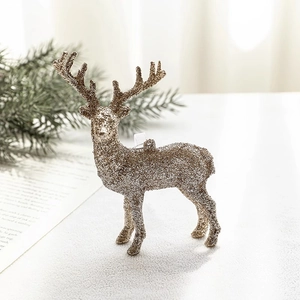 Glittery gold reindeer ornament with bow detail and pine branch holiday decorations