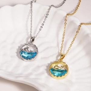 Detailed view of whale tail pendants in gold and silver finish on shell display