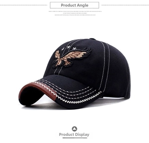 Close-up of eagle embroidery and contrast stitching on a black cotton baseball cap