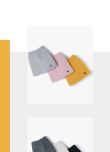 Détail de bonnets en maille côtelée avec écussons logo R en plusieurs couleurs pastel