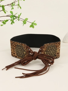 Detail of leopard print wide belt featuring vintage bronze metal rings and suede tassels
