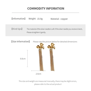 Detailed view of long flower tassel earrings in gold finish with product dimensions