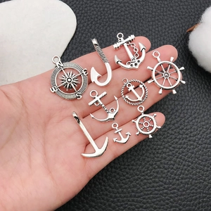 Silver nautical metal charms set featuring anchors and rudders on black background