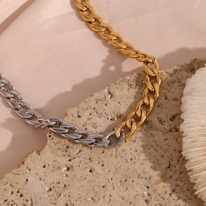 Dettaglio della collana a catena cubana bicolore oro e argento su corallo e conchiglia