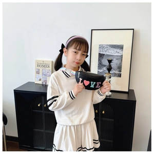Girl wearing black kids chest bag with colorful LOVE letters and rainbow shoulder strap