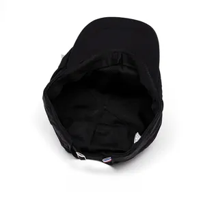Detail of black flat cap showing breathable mesh lining and adjustable metal buckle