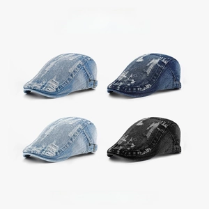 Close-up of vintage distressed denim flat caps showing ripped details and metal buckles