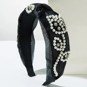 Detail of black mesh headband featuring elegant white pearls and crystal flower patterns