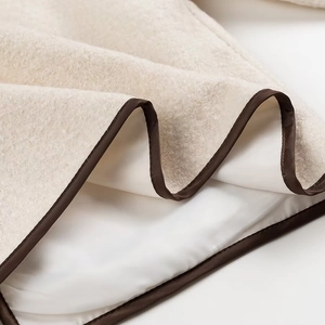 Detailed macro view of fleece fabric texture with brown edge binding and soft lining