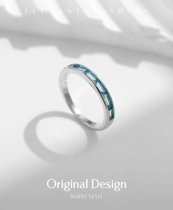 Macro detail of S925 sterling silver band with baguette-cut light blue gemstones