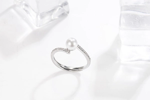 Macro shot of silver adjustable pearl ring with fine pavé diamonds on ice