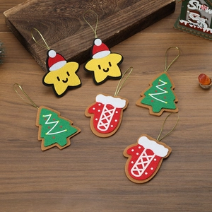 Detail of felt Christmas ornaments including star, glove and tree on wooden background