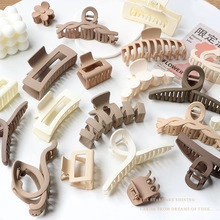 Flat lay of matte hair claw clips in earth tones on aesthetic minimalist background