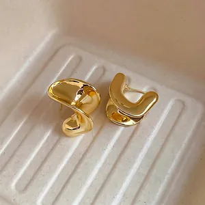 Chic gold plated C-shaped curved earrings with a minimalist abstract metallic design