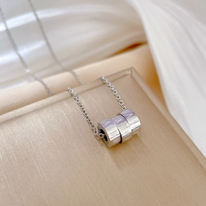 Detailed macro of silver titanium steel Roman numeral cylinder rings on a silk cloth