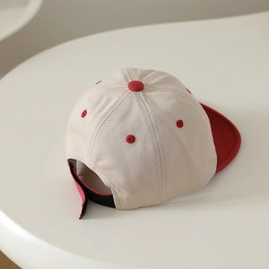 Vue arrière détaillée d'une casquette bébé beige et rouge avec sangle ajustable