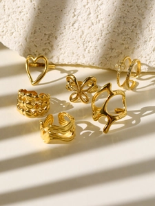 Detail of 6-piece 18k gold plated ring set with butterfly, heart and gothic cross motifs