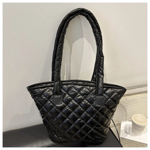 Gros plan sur le sac fourre-tout matelassé noir avec finition brillante et losanges