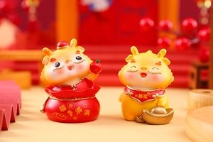Detail of cute resin dragon figurines with lucky red bag and gold ingot decorations