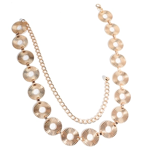 Detailed close-up of a gold metal waist chain featuring textured circular pendants and lobster clasp