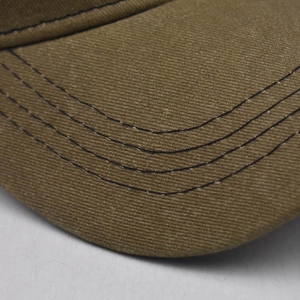 Detailed close-up of khaki baseball cap brim with four rows of black stitching